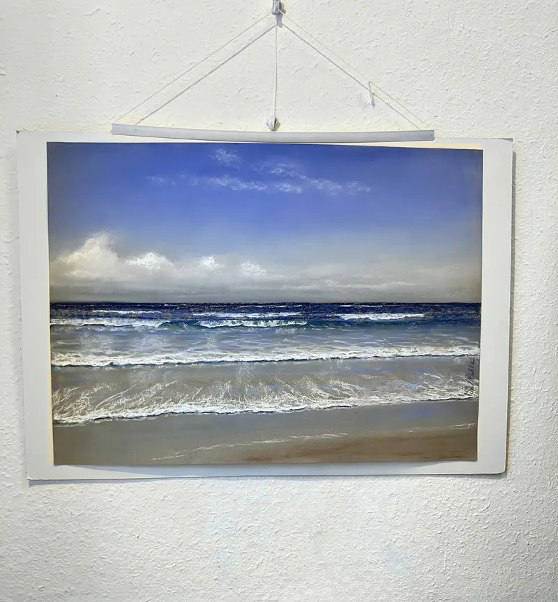 Une marine au pastel accrochée à un mur blanc