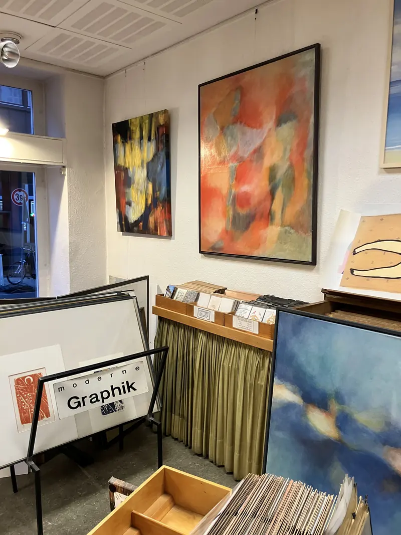 Tableaux abstraits et cartons d’estampes au fond de la boutique