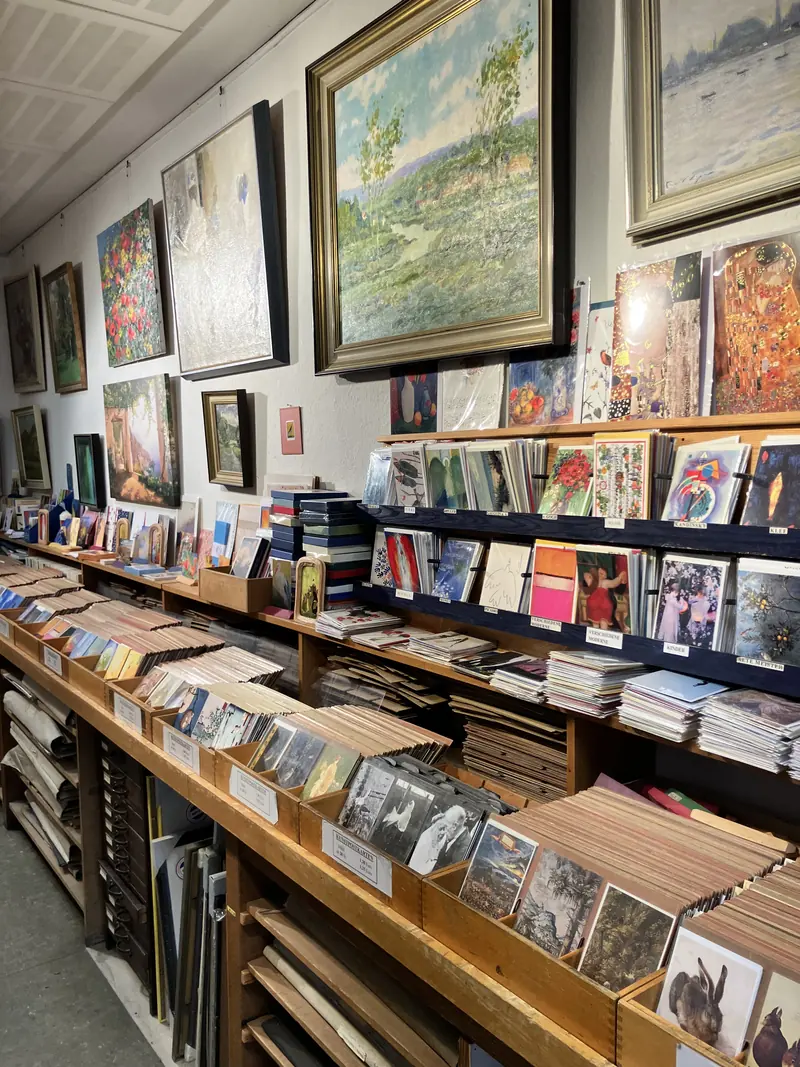 Présentoirs de cartes et tableaux dans des cadres dorés au mur