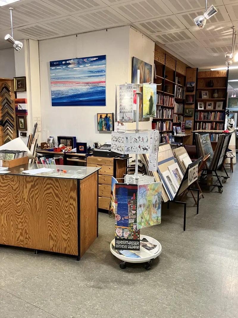 Espace de vente avec comptoir en bois, présentoirs de cartes et bibliothèques